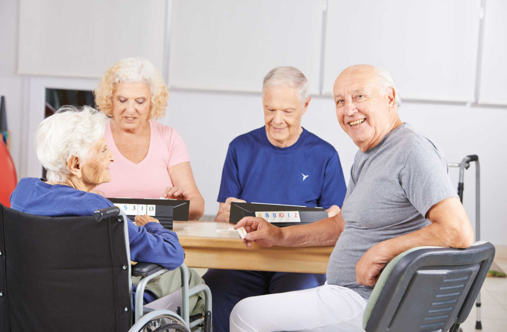Group of senior people playing a game in a memory care community.