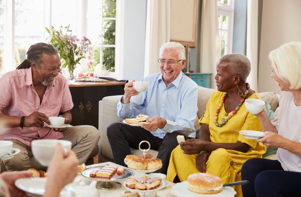 A group of seniors in an independent living community is enjoying afternoon tea together.