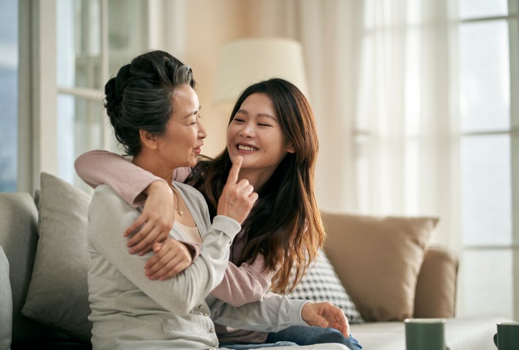 An adult daughter and her senior mother with dementia spending time together at a senior living community.