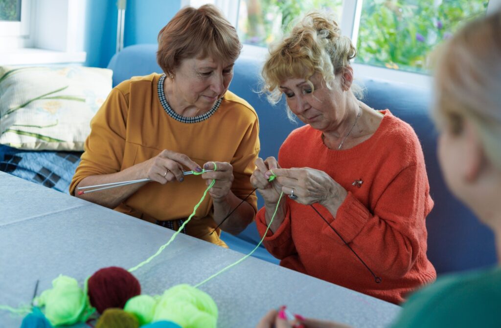 A group of seniors enjoying crocheting together in an assisted living community.