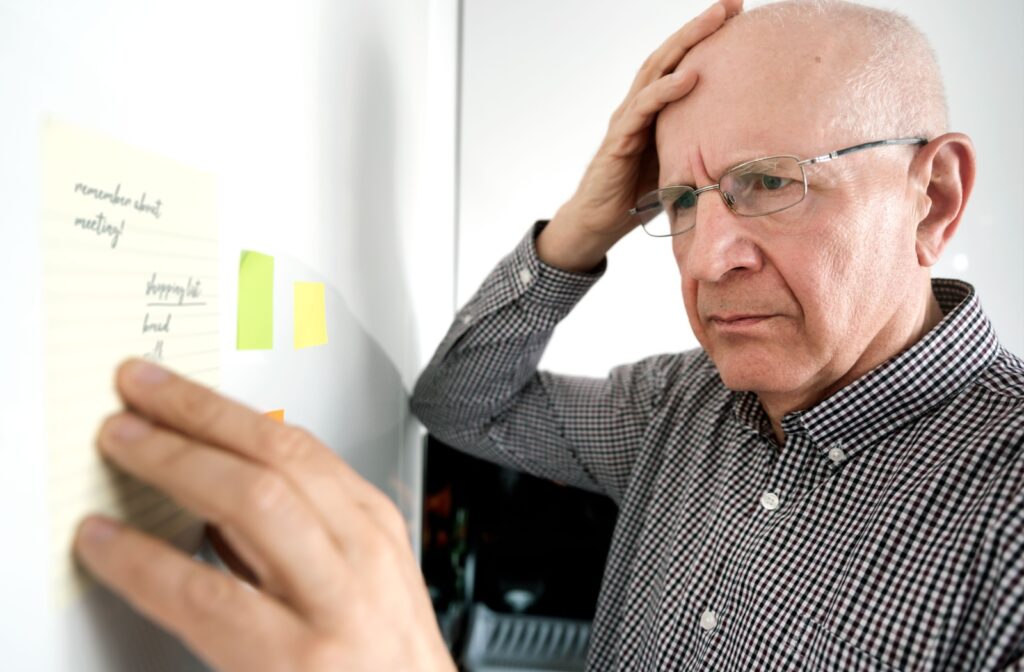 A senior looks in confusion at the post-it notes written for them to remember events and tasks they can’t remember leaving